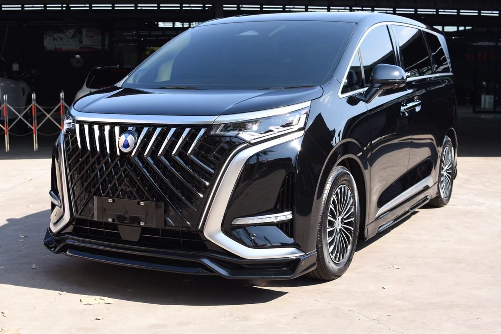 รถ MPV สีดำผิวเงางามจอดบนลานคอนกรีต